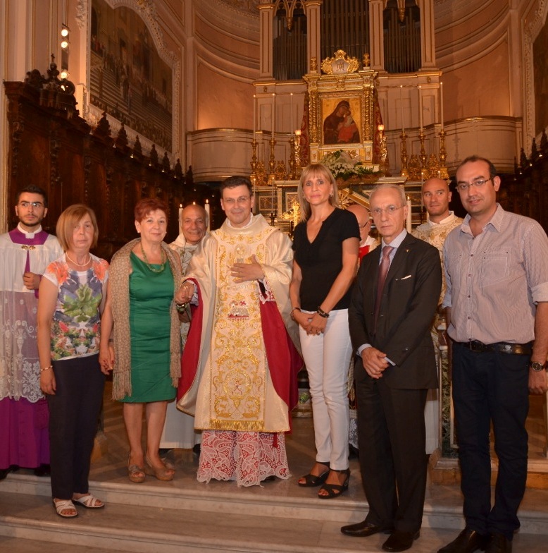 Don Pino Salerno indossa  la nuova Casula sacerdotale.  Qui ritratto assieme all'equipe di lavoro impegnata alla realizzazione del medesimo parato sacro. 